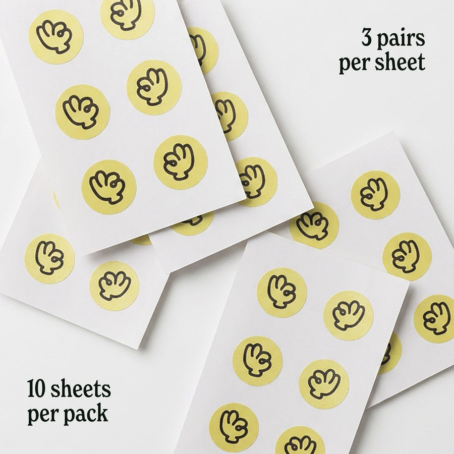 Several sheets of Suckers nipple stickers fanned out, showing three pairs per sheet and ten sheets per pack